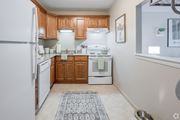 Warwick apartment for rent - A kitchen with wooden cabinets and a white refrigerator.